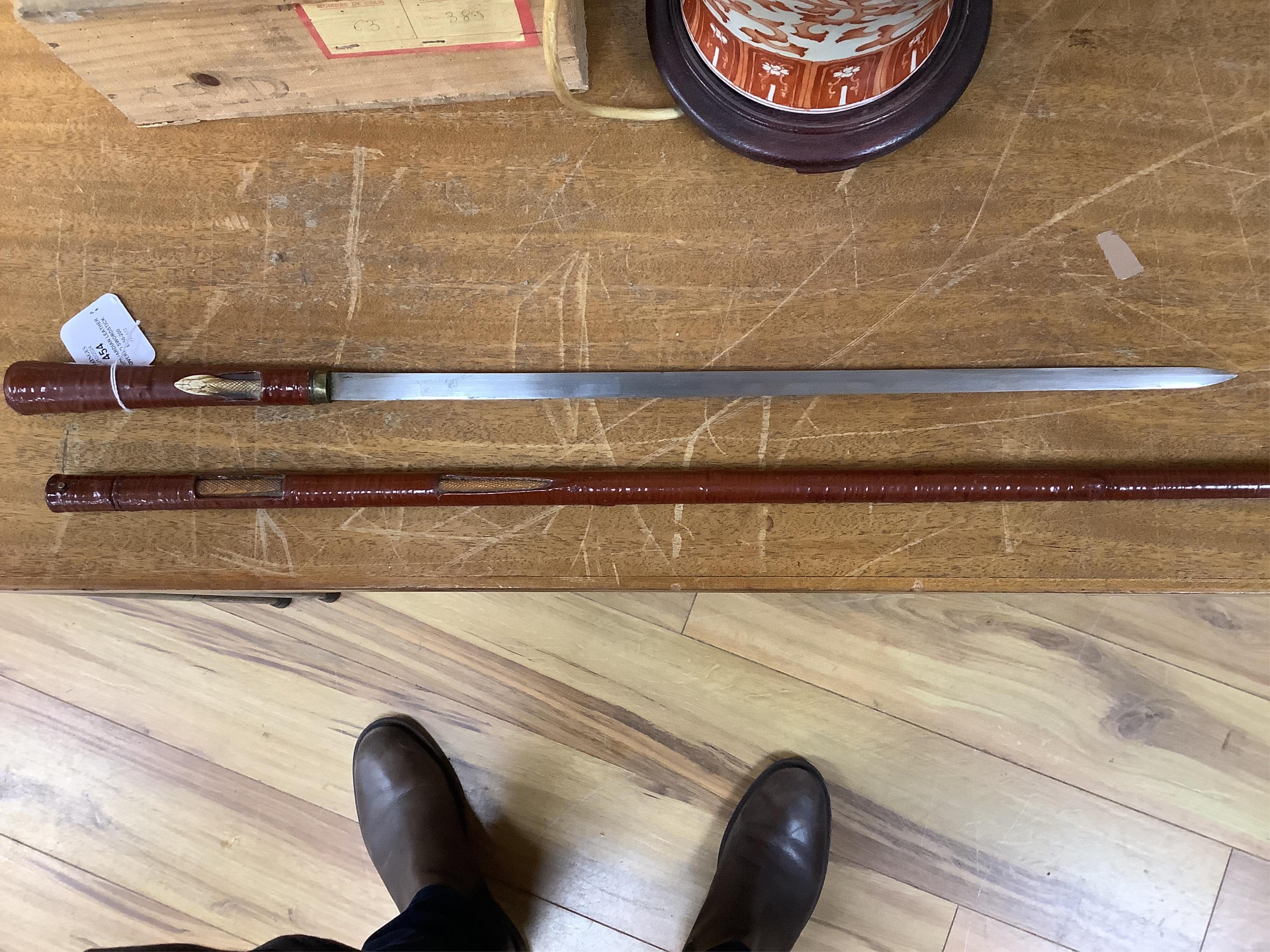 An Edwardian leather covered swordstick with ivory serpent to the shaft, blade 45cm, overall length 89cm. Condition fair to good, minor losses to leather work. CITES Submission reference, CKA5P6DV